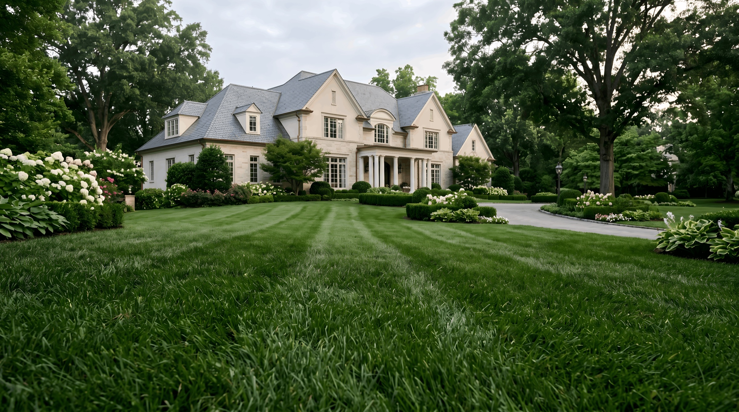 A Forest Hills estate with a lush, striped front lawn